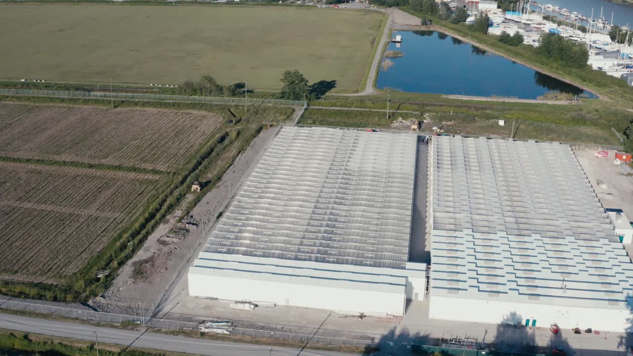 vista aérea de pájaro volar sobre bobwire givernment regulado seguro cultivo de cannabis instalación de precios invernadero junto a la bodega granja de arándanos en richmond bc canadá conectado al puerto del río fraser