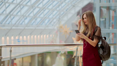 Smiling-female-blogger-listening-favorite-songs-in-headphones-while-posing-for-selfie-on-smartphone-camera,-hipster-girl-enjoying-radio-broadcast-making-photo-for-picture-in-social-networks-on-mobile.