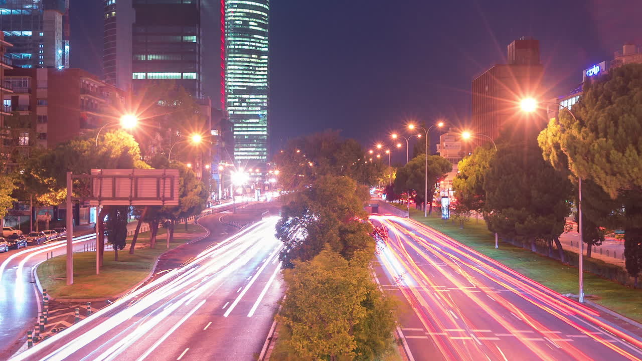 Night close up timelapse of car trails and Cuatro torres business area in Madrid, Spain. Aerial view.