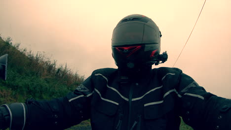 Biker-selfie-video-riding-through-a-wet-landscape-in-Scotland-through-farms-and-towns