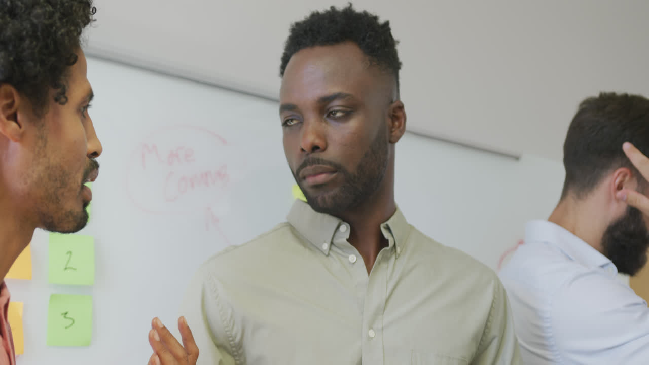 Diverse male business colleagues discussing at meeting in office