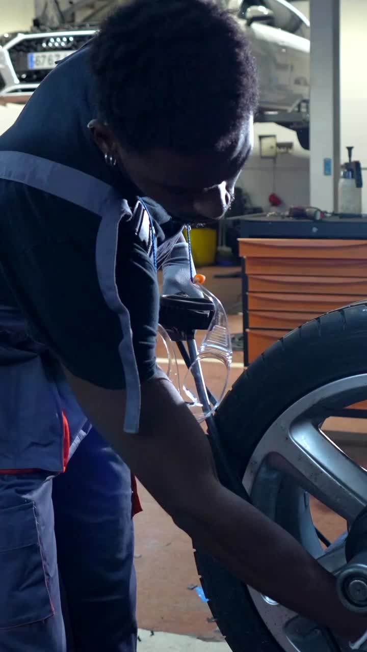 Car Mechanic Repairing Tire in Auto Shop