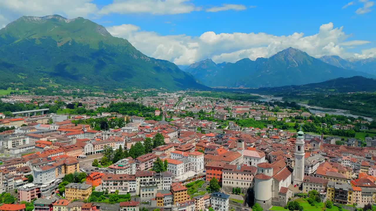 Experience the beauty of Belluno as the drone glides over its picturesque rooftops, revealing the intricate architecture and vibrant colors of this historic city