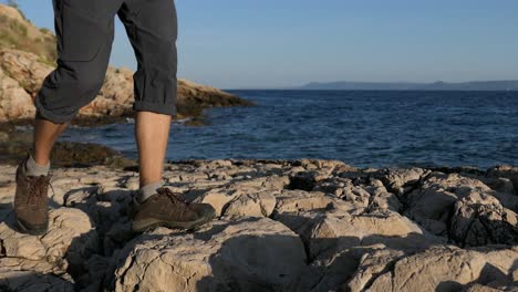 Calm-walk-by-the-sea,-man-walking-on-rocky-seashore