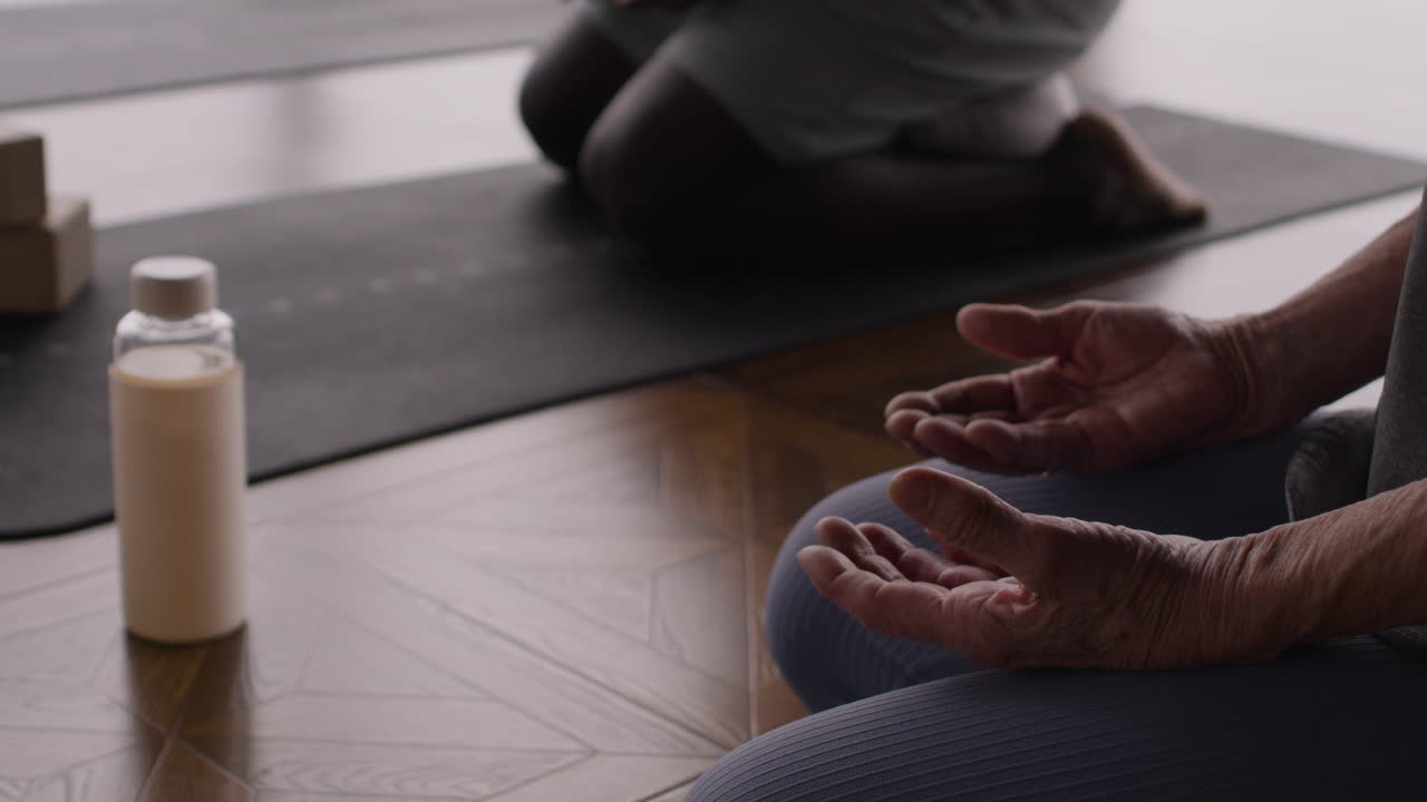 Elderly Person Meditating in Yoga Class