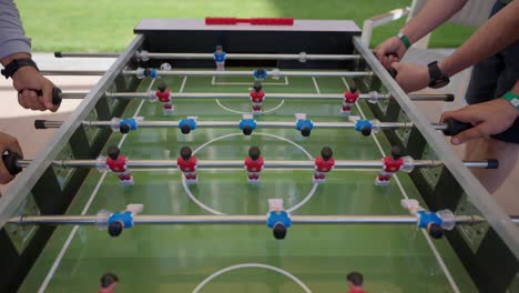 foosball competition between young men in the hall insert shot, push in shot, push out shot