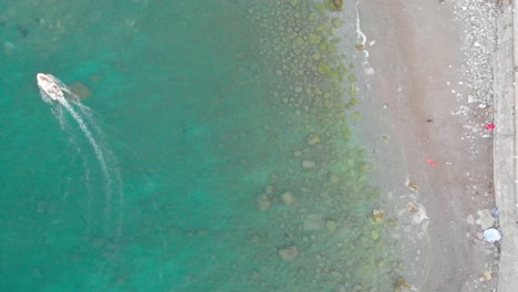 Drohnenaufnahmen-Aus-Der-Vogelperspektive-Vom-Strand-Mit-Sich-Bewegendem-Boot