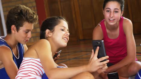 niños de secundaria usando teléfonos móviles