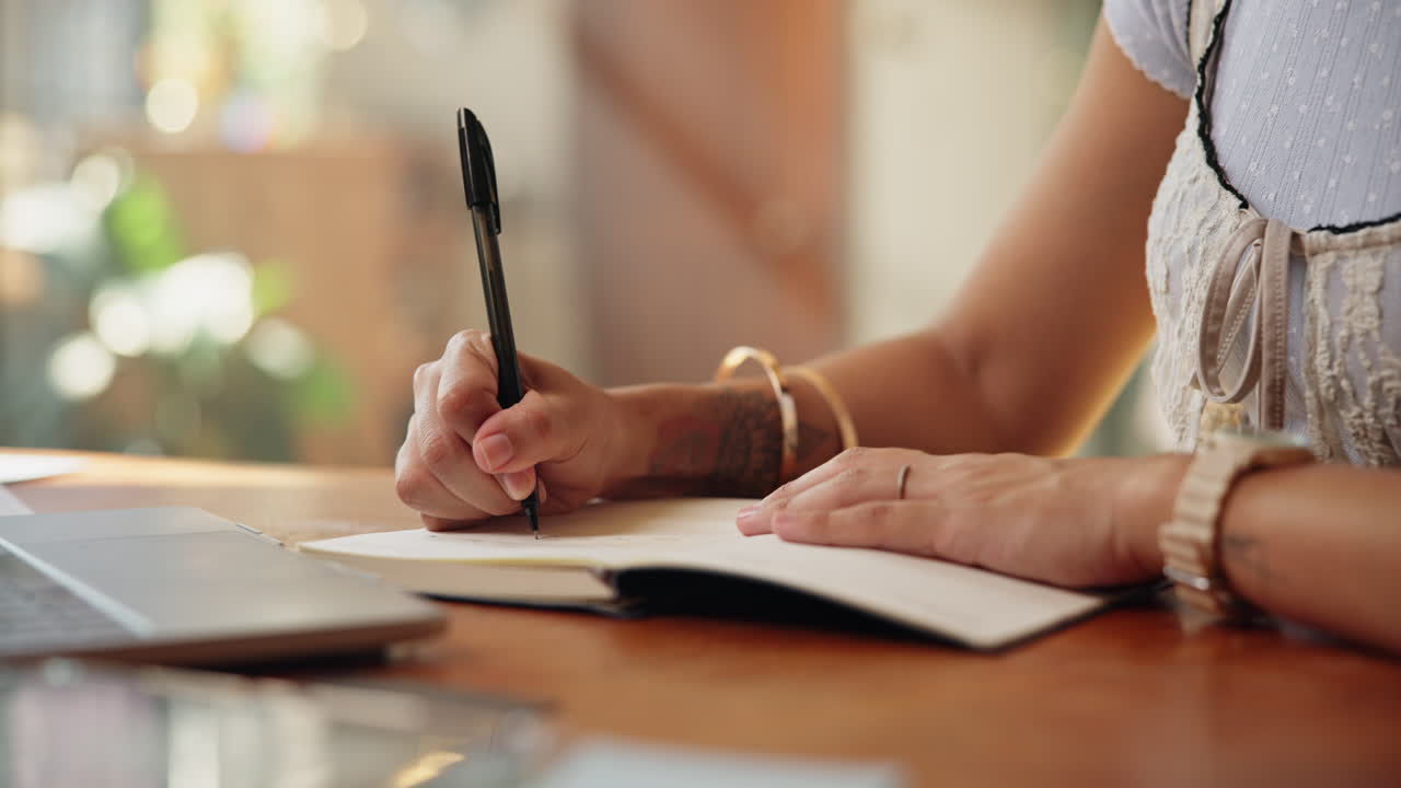 Close Up of Person's Hands Writing in a Notebook