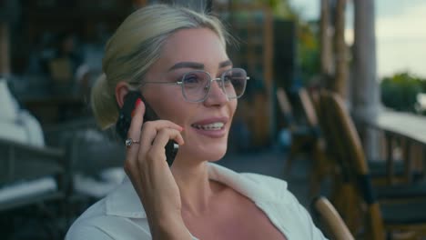 woman talking on phone in outdoor cafe