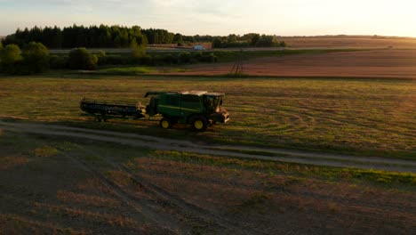 agriculture-machine-standing-in-field,-person-climbs-on-it-and-raises-both-hands