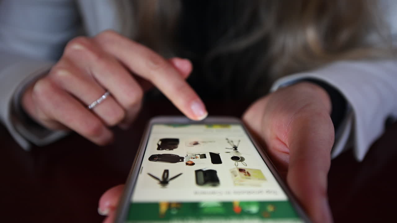 CHISINAU, MOLDOVA - NOVEMBER, 2021: Woman working on mobile phone in a restaurant at lunch, navigating amazon store