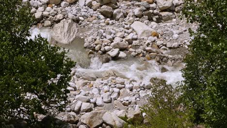 Hermosa-Toma-Cinematográfica-Del-Río-Ganges-Que-Brota-Del-Vapor-Desde-El-Origen-En-La-Región-De-Uttarakhand,-India,-Enmarcada-Por-árboles.