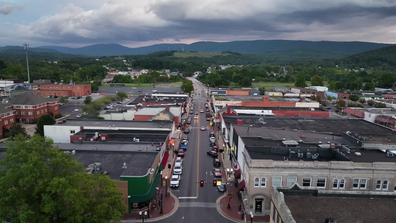 Descend drone shot of junction and Main Street of downtown in waynesboro, Virginia. Historic houses and buildings with mountains in distance