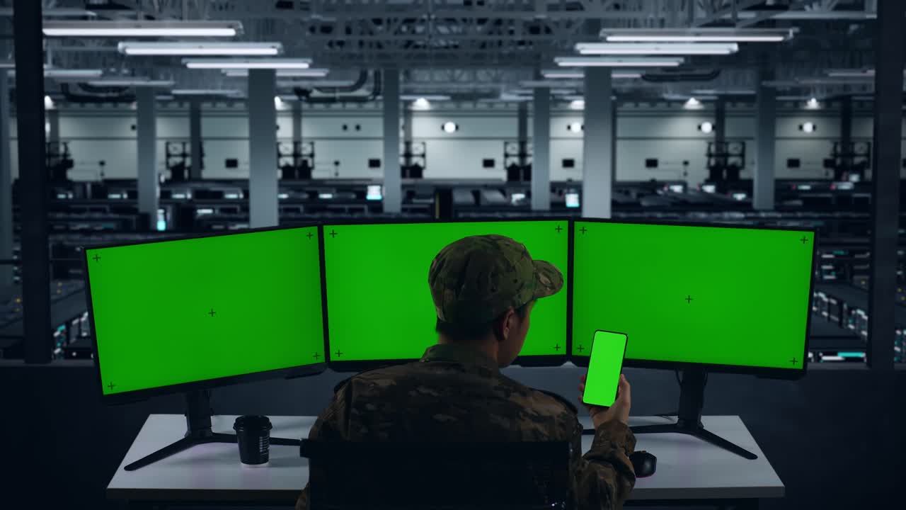 데이터 센터에서 모의 녹색 화면과 함께 휴대 전화 및 여러 컴퓨터 모니터를 사용하여 아시아 군대의 뒷면