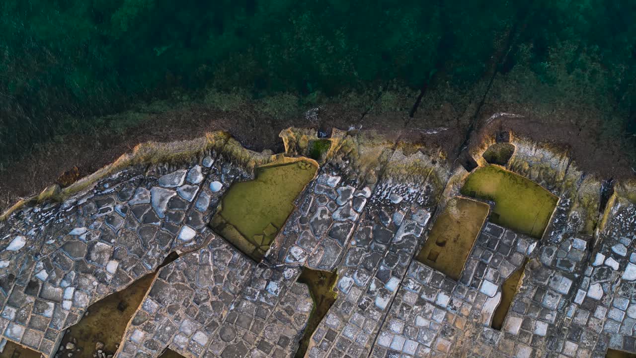 Salt pans on Marsaskala coastline, Malta, descending overhead aerial view