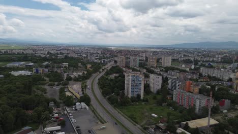 establishing aerial shot of the edges of sofia city with old communist-era apartment buildings with a lot of green trees in between
