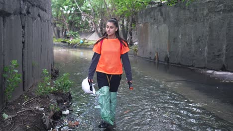 mujer inspeccionando una vía fluvial urbana