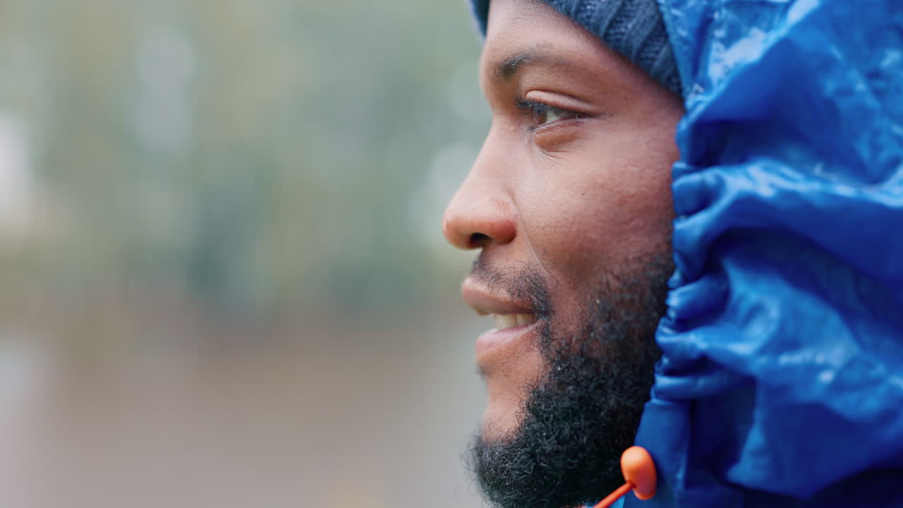 perfil, espacio y un hombre negro caminando bajo la lluvia