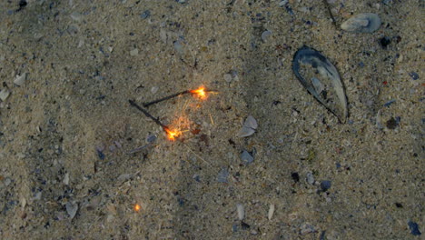 high angle view of sparklers on sand at beach 4k