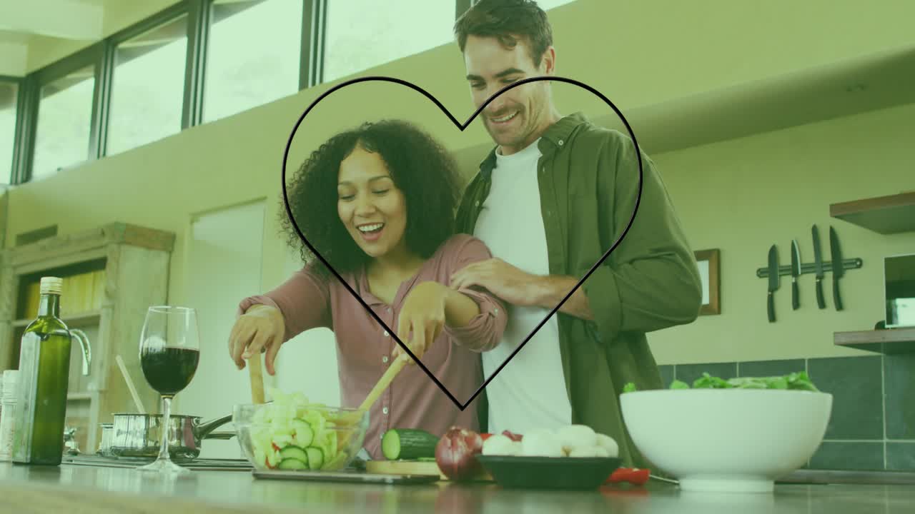 Woman tossing salad in kitchen initiating neon heart graphic around couple celebrating meal prep