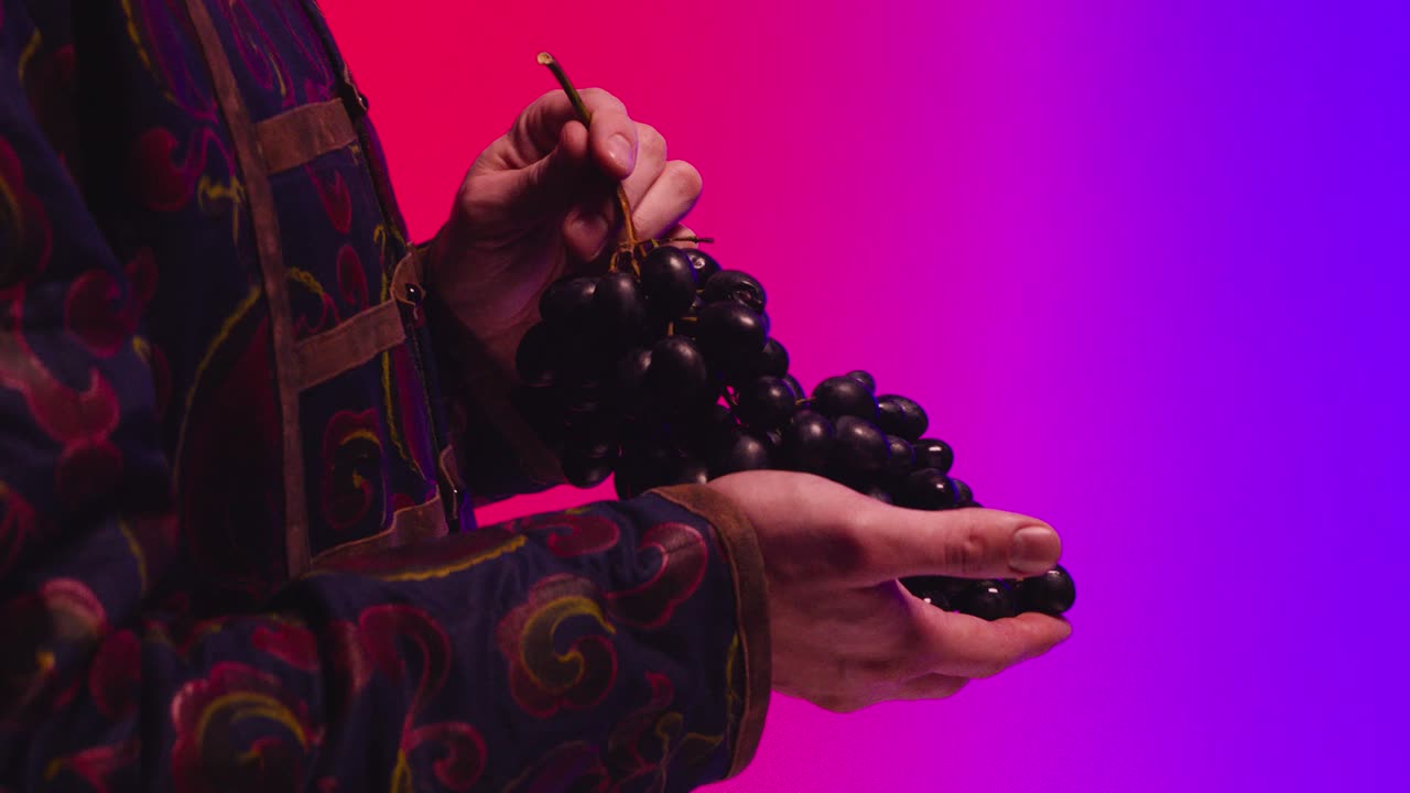 manos ofreciendo uvas contra un fondo gradiente