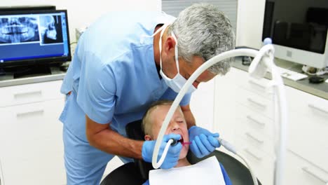 Dentist-examining-a-young-patient-with-tools