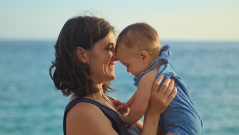 mother and daughter sitting on the beach and hugging.