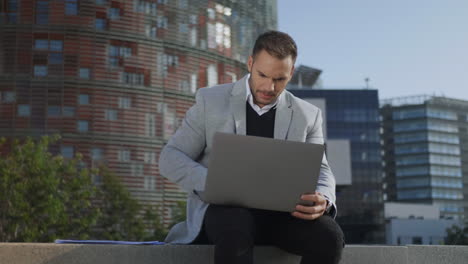 business man working on laptop in city. worker browsing internet on computer