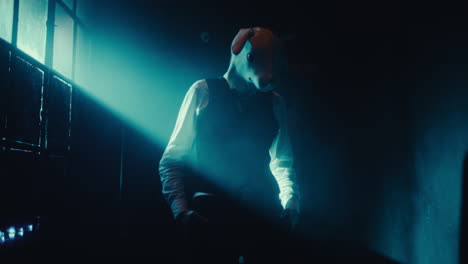 mysterious figure in rabbit mask under blue spotlight