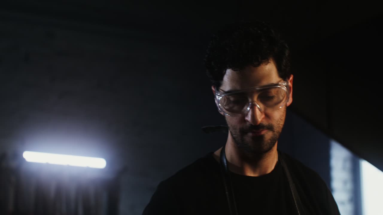 hombre trabajando en un taller oscuro