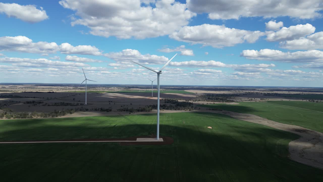 Towering wind turbines producing green energy built on an country cattle farm