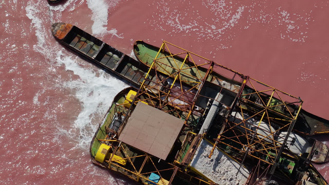 Aerial view of a ship wreck in a pink lake