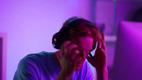 disappointed gamer losing cyber battle closeup. upset ginger man taking headset