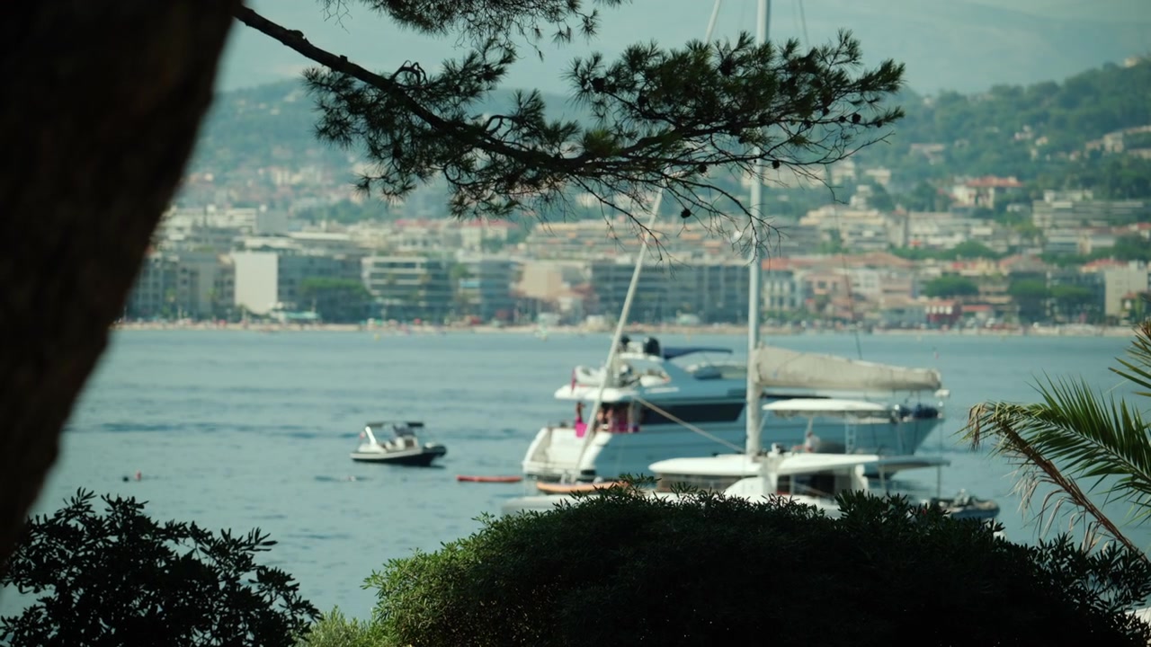 Yacht di lusso ancorato nella baia di Cannes, Costa Azzurra. Persone che si rilassano sul ponte, godendosi le vacanze estive e la ricchezza.