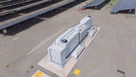 sistema de almacenamiento de baterías en una granja solar rodeada de paneles fotovoltaicos