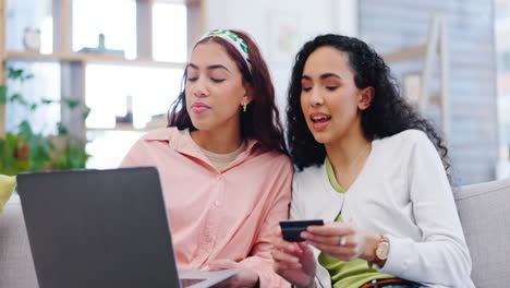 laptop, credit card and women friends on sofa
