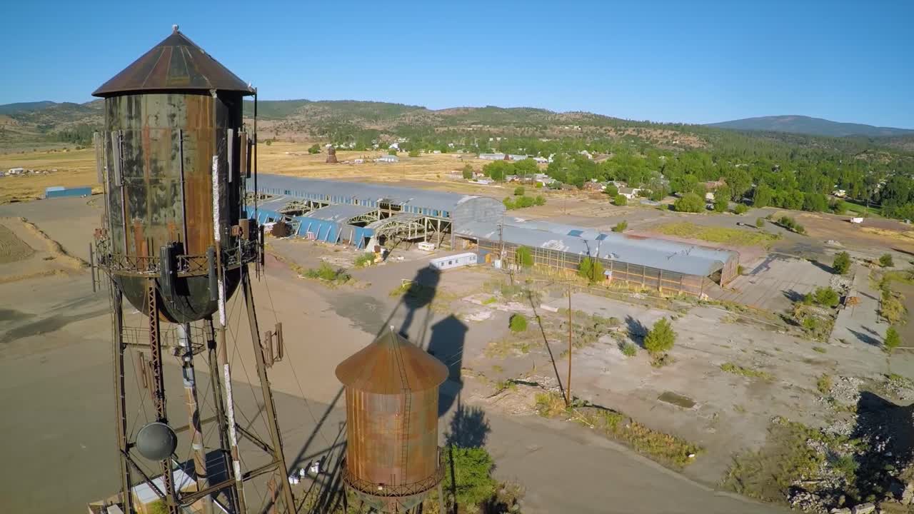 una toma aérea sobre un molino de fábrica abandonado y torres de agua en el norte de california