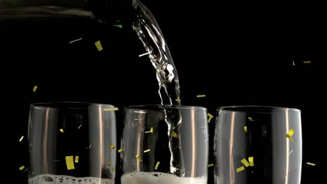 animation of gold confetti falling over champagne glasses on black background