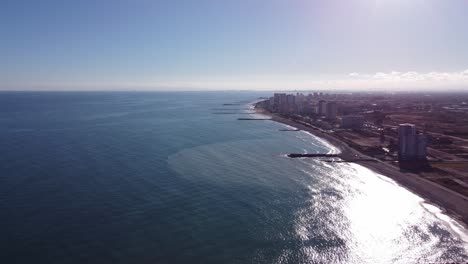 Mediterranean-seaside-coast-in-Valencia-Spain,-sun-reflexion-in-water,-aerial