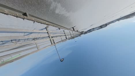 Rolling-Up-Footage-of-The-Bridge-Trapped-By-The-Ice-Of-A-Frozen-River-On-A-Sunny-Summer-Day