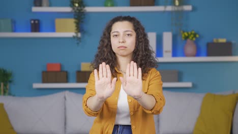 mujer joven haciendo una señal de alto para la cámara.
