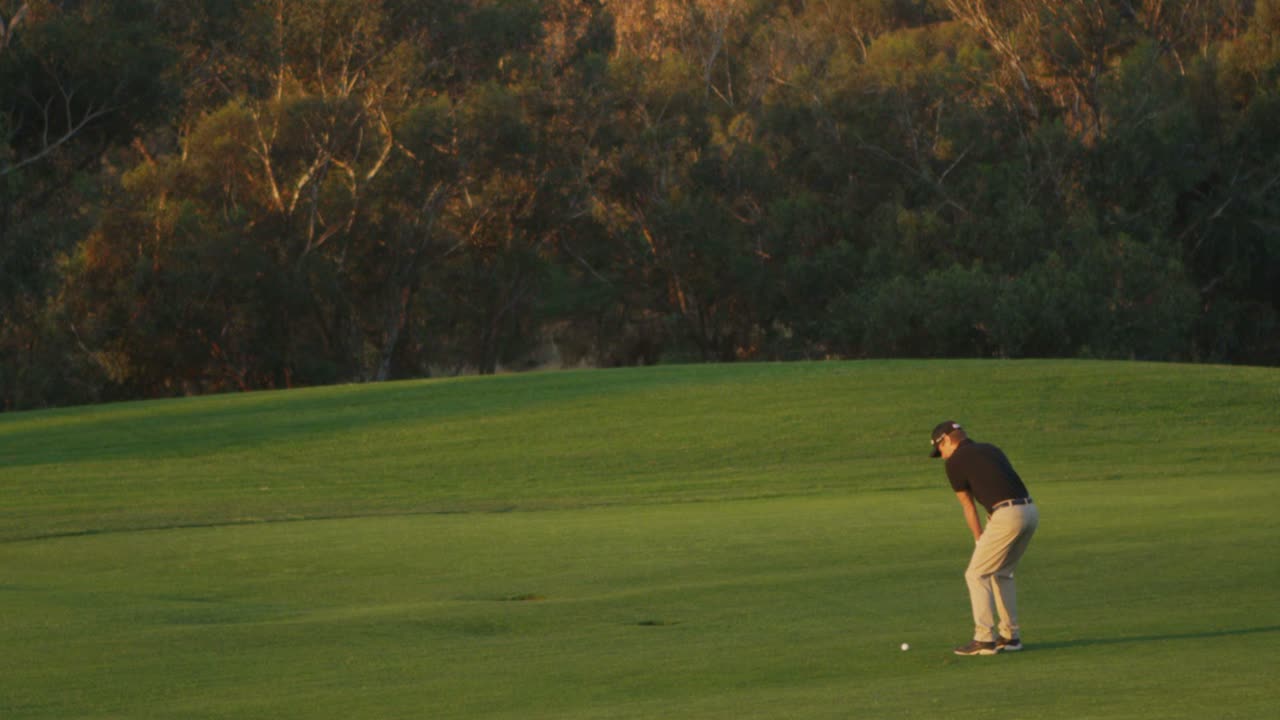 un golfista hace un swing en un campo de golf