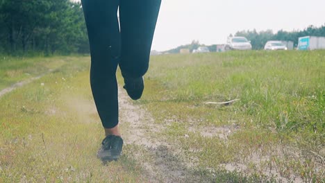 CU-Slow-motion-Low-angle-shot-Young-girl-goes-in-for-sports-in-the-morning-runs-along-a-pine-forest