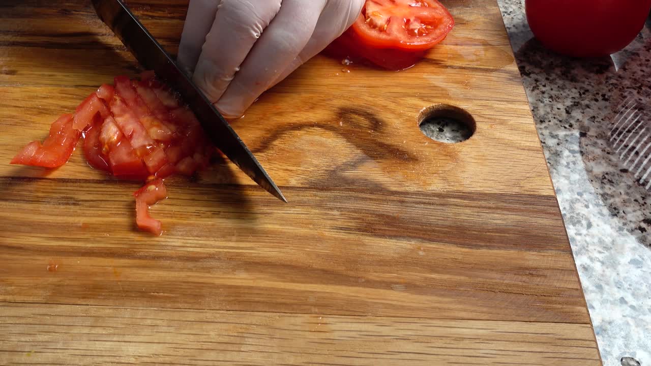el cocinero corta tomates en una tabla de cortar.