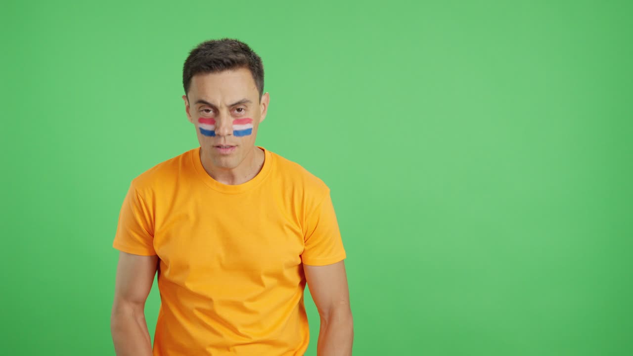 Man standing with dutch flag painted on face smiling