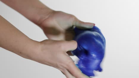 Woman-hands-playing-with-oddly-satisfying-blue-slime-gooey-substance.-Antistress