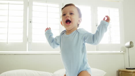 cute baby jumping on a bed