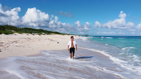 Joven-Atlético-Bronceado-Con-Camisa-Blanca-De-Playa-Caminando-En-Una-Isla-Tropical-De-Arena-En-Cozumel-México