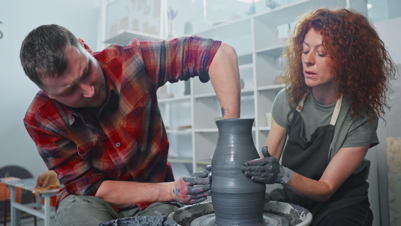 Couple creating pottery on a pottery wheel